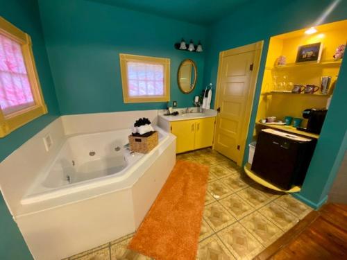 a bathroom with a large tub and a sink at Rock Cottage Gardens B&B in Eureka Springs