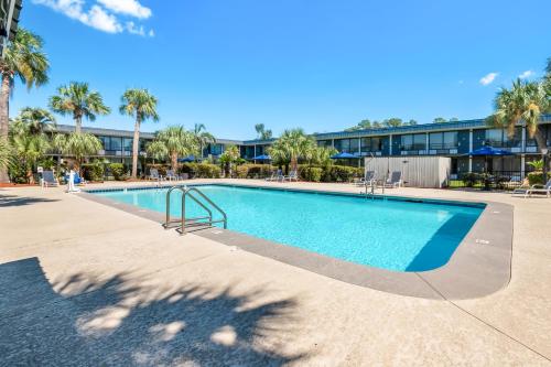 a swimming pool at a resort with palm trees at Quality Inn Slidell I-10 in Slidell