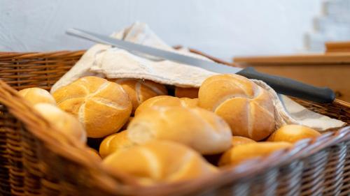a basket filled with loaves of bread with a knife at Pension Hofweyer in Ramsau am Dachstein