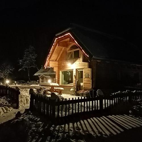 a house with lights on the front of it at night at Alpi Giulie Chalets in Valbruna