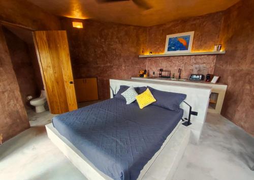 a bedroom with a bed with blue sheets and yellow pillows at Estudio Nacui in El Sargento