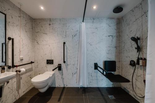 a bathroom with a toilet and a sink and a shower at The Halyard Liverpool, Vignette Collection by IHG in Liverpool