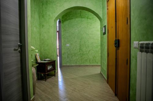 a hallway with green walls and an arched doorway at MontagnaVivaCilento in Piaggine