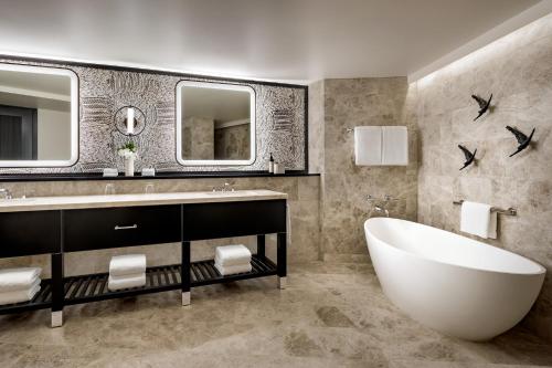 a bathroom with a tub and a sink and mirror at Fairmont Kea Lani, Maui in Wailea