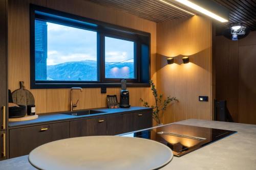 a kitchen with a sink and a large window at Aurora Escape in Tromsø