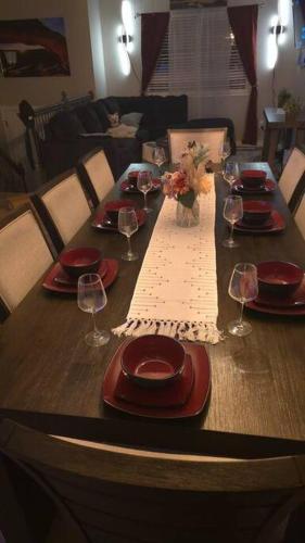 a wooden table with red plates and wine glasses at Colorado Four Season Funhouse in Colorado Springs