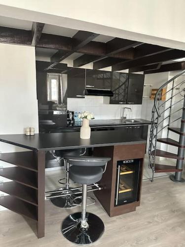 une cuisine avec un comptoir noir et un évier dans l'établissement Premium House en Hypercentre - Parking inclus et à 7 mins RER A, à Saint-Germain-en-Laye