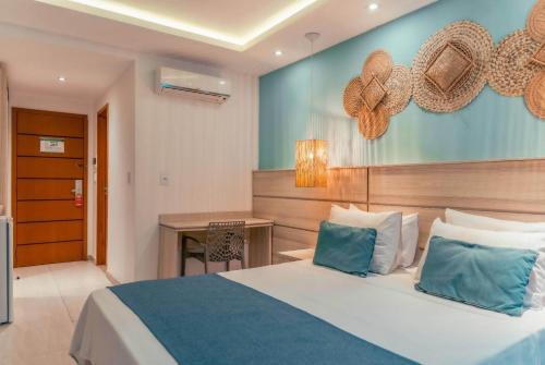 a hotel room with a bed and a desk at Paradiso Peró Praia Hotel in Cabo Frio