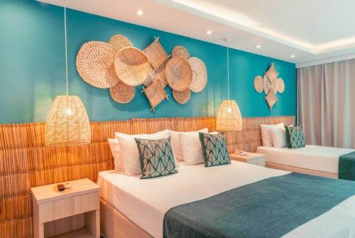 a hotel room with two beds and a couch at Paradiso Peró Praia Hotel in Cabo Frio