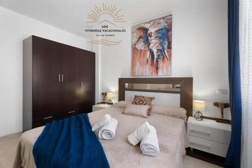 Un dormitorio con una cama grande con toallas. en Apartamento Oasis Tropical, en Candelaria