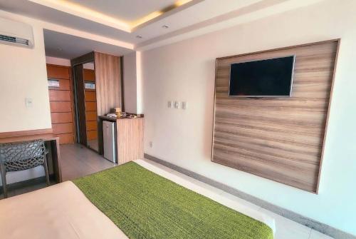 a hotel room with a flat screen tv on the wall at Paradiso Peró Praia Hotel in Cabo Frio