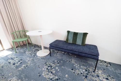 a room with a table and a chair and a table and a couch at Currimundi Hotel in Caloundra
