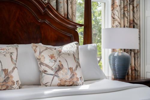 a bed with two pillows and a table with a lamp at Hamilton Turner Inn in Savannah