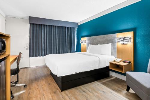 a bedroom with a large bed and a blue wall at Quality Inn Slidell I-10 in Slidell