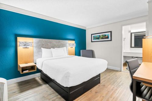 a hotel room with a bed and a blue wall at Quality Inn Slidell I-10 in Slidell
