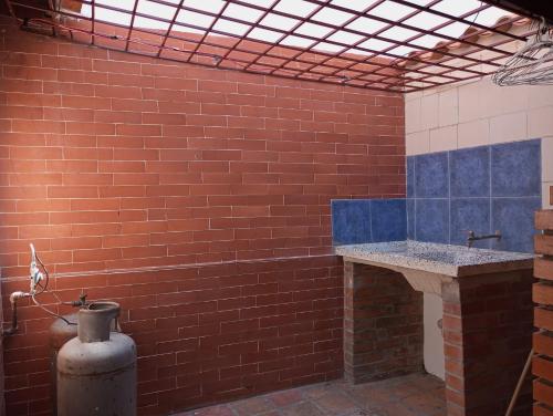 a bathroom with a red brick wall and a sink at Casa Completa Concordia Andina Bien Ubicada Mérida in Mérida