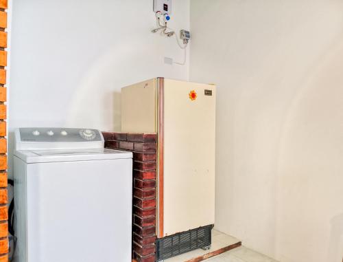 a white refrigerator in a kitchen next to a brick wall at Casa Completa Concordia Andina Bien Ubicada Mérida in Mérida