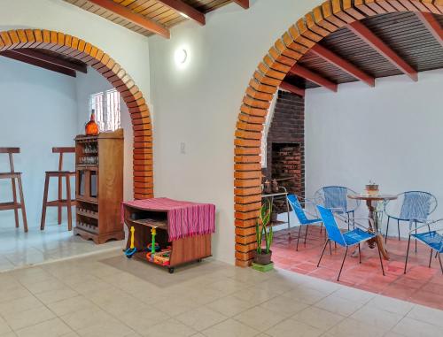a living room with two arches and a table and chairs at Casa Completa Concordia Andina Bien Ubicada Mérida in Mérida