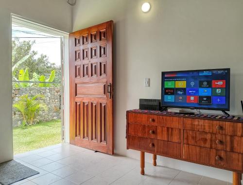 a room with a television on a dresser with a door at Casa Completa Concordia Andina Bien Ubicada Mérida in Mérida