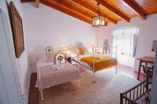 a bedroom with two beds and a table at Casa Azenha das Freiras in Borba