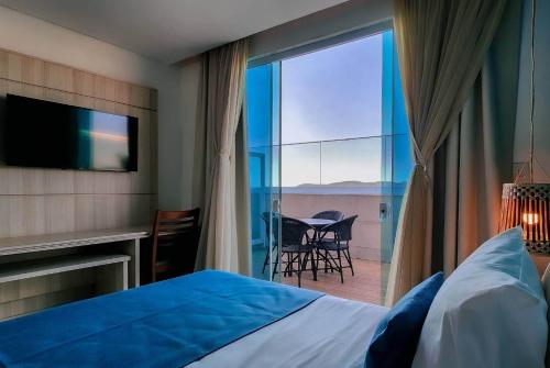 a bedroom with a bed and a view of a patio at Paradiso Corporate in Cabo Frio