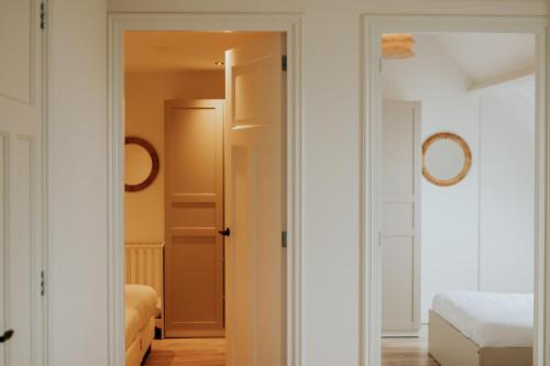 a bedroom with a door open to a room with a bed at Villa aan het water met hottub in Dokkum