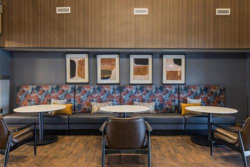 コロンバスにあるFour Points by Sheraton Columbus-Polarisのソファとテーブル2台付きの待合室
