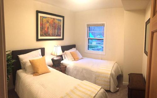 Un dormitorio con dos camas y una ventana en Creekside Craftsman Cabin with Jacuzzi - Alpine Splendor 6 Mins to downtown, en Boulder