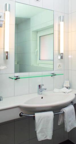 a bathroom with a sink and a mirror at Hotel Sonne in Altstätten