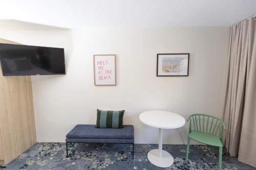 a room with a table and two chairs and a tv at Currimundi Hotel in Caloundra