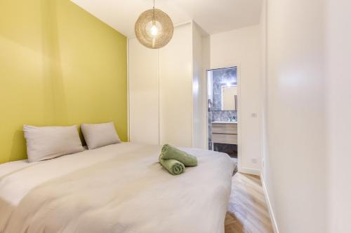 - une chambre dotée d'un grand lit avec un oreiller vert dans l'établissement Le Paname - Parking Gratuit - Clim - WiFi - Métro 9 - Paris Proche, à Montreuil