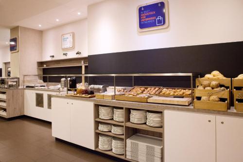 a kitchen with a counter with a lot of food at Holiday Inn Express Friedrichshafen by IHG in Friedrichshafen