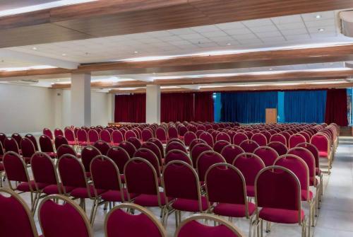 an empty room with red chairs and red curtains at Paradiso Corporate in Cabo Frio