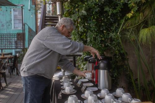 a man is pouring tea into a coffee pot at Hotel Boutique 17 in Valparaíso