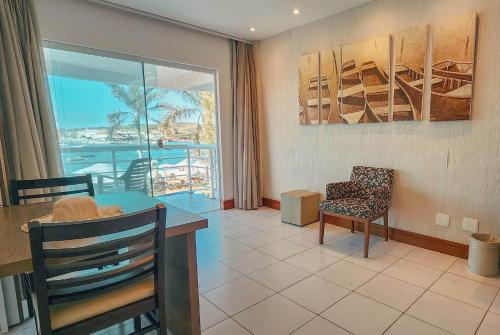 a living room with a table and chairs and a window at Hotel Paradiso del Sol in Cabo Frio