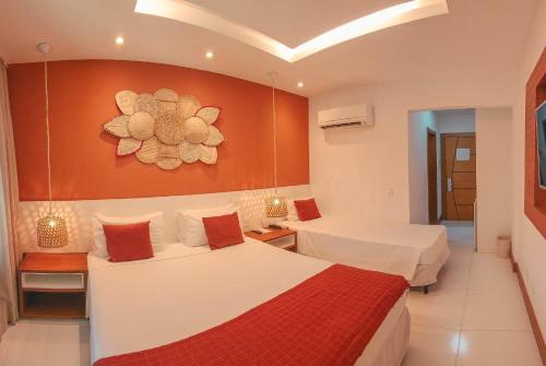 a hotel room with two beds and a painting on the wall at Hotel Paradiso del Sol in Cabo Frio