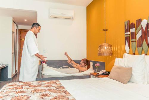 a man standing next to a woman in a bath tub at Hotel Paradiso del Sol in Cabo Frio