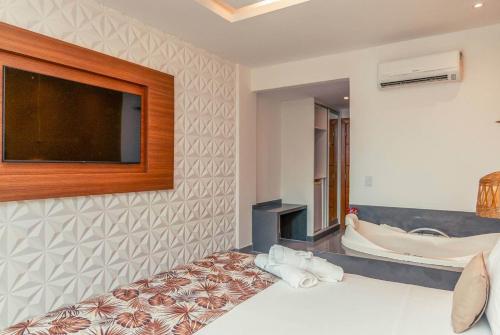 a bedroom with a bed and a tv on a wall at Hotel Paradiso del Sol in Cabo Frio