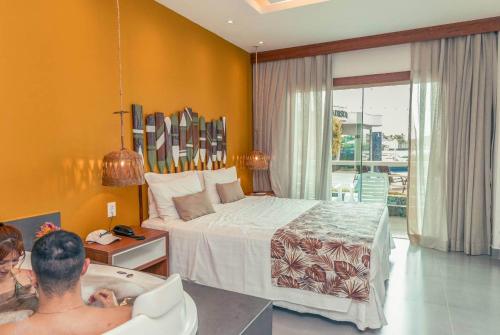 a man sitting in a bath tub in a bedroom at Hotel Paradiso del Sol in Cabo Frio