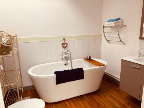 une baignoire blanche dans une salle de bain avec un lavabo dans l'établissement Gites Rue Du Chateau, à Ruffec