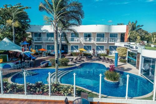 a hotel with a large swimming pool in front of a building at Hotel Paradiso del Sol in Cabo Frio