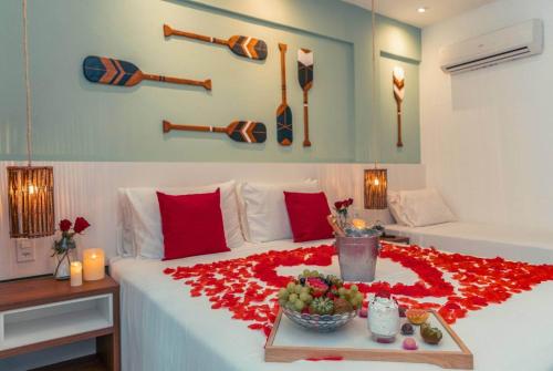 a bedroom with a large bed with a red rose blanket at Hotel Paradiso del Sol in Cabo Frio