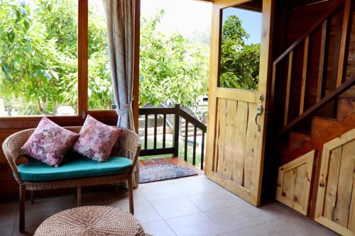 a porch with a chair and an open door at Molino de Café Cabañas Lodge in Chinchín Loma