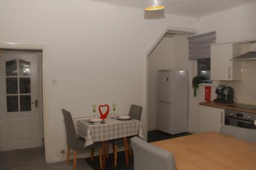 a kitchen with a table with chairs and a refrigerator at Spacious House, Near Haigh Woodland Park, Wifi, Parking in Leigh