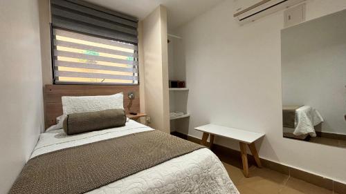 a bedroom with a bed and a window and a table at Hotel La Gloria in Mompos
