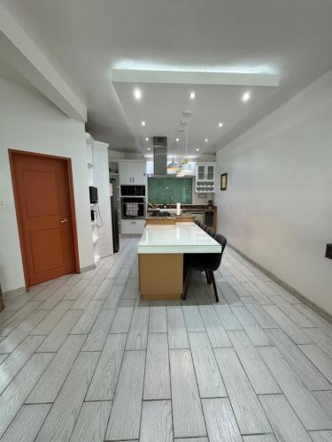 a large kitchen with a table in the middle of a room at Beautiful House in Matamoros in Matamoros