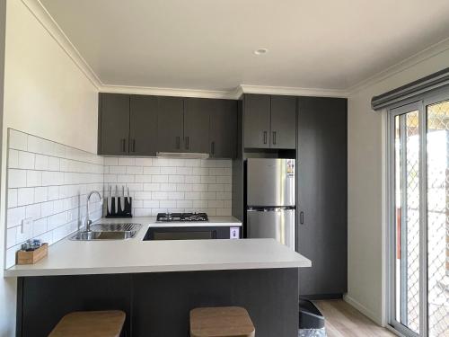 a kitchen with black cabinets and white appliances at Kerang Holiday park in Kerang