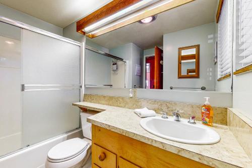 ein Badezimmer mit Waschbecken, Toilette und Spiegel in der Unterkunft Clemons' Cottage in Sea Ranch