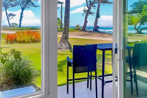 a table and chairs in a room with a view of the ocean at Islander on the Beach 164 in Kapaa