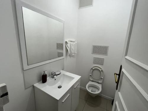 une salle de bain blanche avec un lavabo et des toilettes dans l'établissement Appartement Quartier Grande Armée Paris 100 m2, à Paris